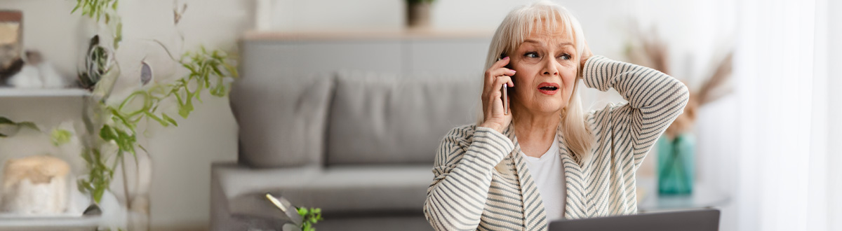 Older woman with a surprised look, talking on the phone
